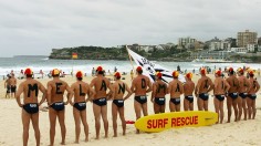 Volunteer lifesavers pose as a human billboard, forming the phrase 