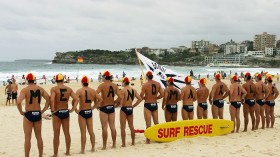 Volunteer lifesavers pose as a human billboard, forming the phrase 