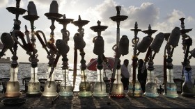 People walk past water pipes near the beach in Alexandria, Egypt, during the first day of Eid, August 30, 2011. The Eid al-Fitr festival marks the end of the Muslim fasting month of Ramadan.