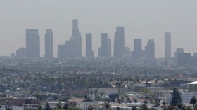 The skyline of downtown Los Angeles through a layer of smog is seen in the distance from a rooftop in Hollywood, California, May 31, 2006