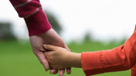 Child holding hands with adult