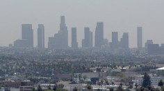 The skyline of downtown Los Angeles through a layer of smog is seen in the distance from a rooftop in Hollywood, California, May 31, 2006.