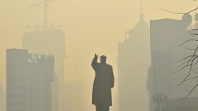 A statue of China's late Chairman Mao Zedong is seen in front of buildings during a hazy day in Shenyang, Liaoning province, May 7, 2013