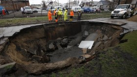 Workers look into a sinkhole caused by a broken water main in Chicago, Illinois, April 18, 2013