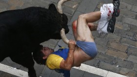 A runner gets gored by a bull on Estafeta street during the sixth running of the bulls of the San Fermin festival in Pamplona July 12, 2013.