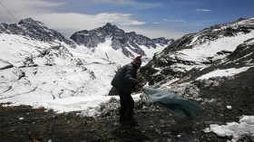 A man clears snow on La Cumbre, some 30 km (18.6 miles) near La Paz, August 28, 2013. Unusually heavy snowfall has been reported on the highlands in Bolivia, according to local media