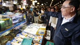 South Korea's Prime Minister Jung Hong-won holds up a domestic fish