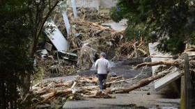 A man walks near collapsed houses following a landslide caused by Typhoon Wipha on Izu Oshima island, south of Tokyo, in this photo taken by Kyodo October 16, 2013