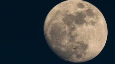 A Plane Is Dwarfed As It Flies Past The Moon