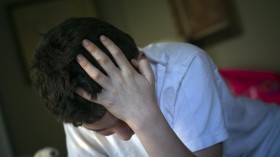 Matthew Kolen, who was diagnosed at age eight with Asperger's syndrome, puts his hand over his head while doing his homework in Long Island, New York April 16, 2012. mental health