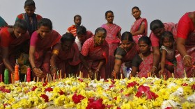 women light candles during a prayer ceremony for the victims of the 2004 tsunami on the ninth anniversary of the disaster, at Marina beach in the southern Indian city of Chennai December 26, 2013. 