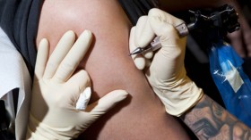 a tattoo artist preparing to tattoo a man's bare arm