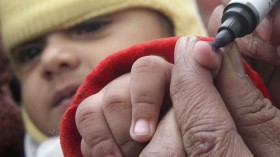 a health worker marks the finger of a child after administering a polio vaccine at a polio booth in the northern Indian city of Chandigarh January 10, 2010. 