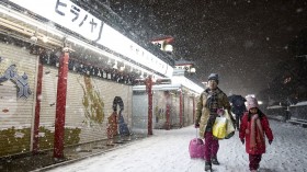 People walk on a street during a heavy snowfall in Asakusa district in Tokyo February 8, 2014.