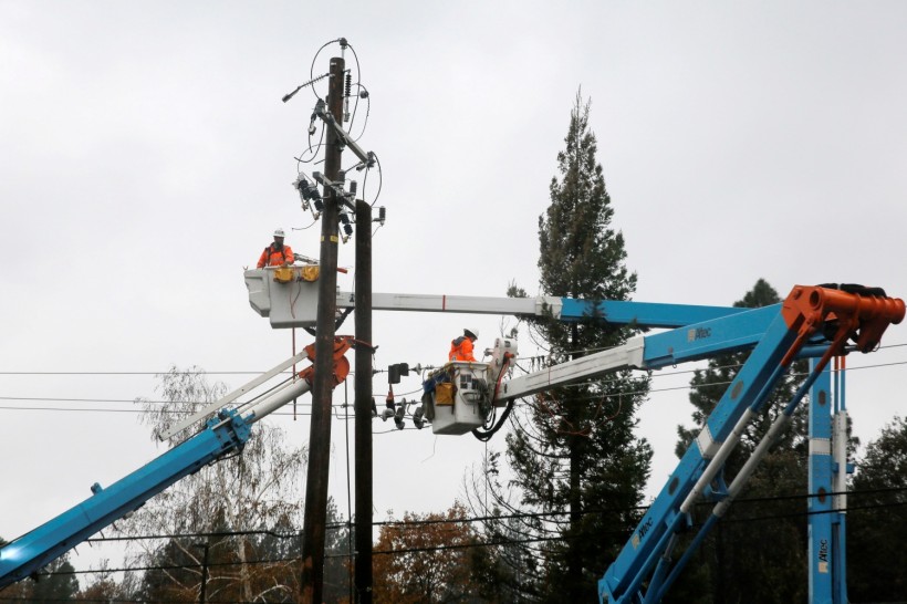 FILE PHOTO: PG&E crew work on power lines to repair damage caused by the Camp Fire in Paradise, California