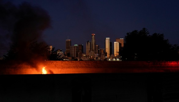A car burns after catching on fire along the side of the 101 highway in Los Angeles