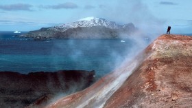 man standing in volcanic steam in Antarctica.