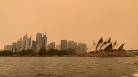 FILE PHOTO: The haze from bushfires obscures the sun setting above the Sydney Opera House in Sydney