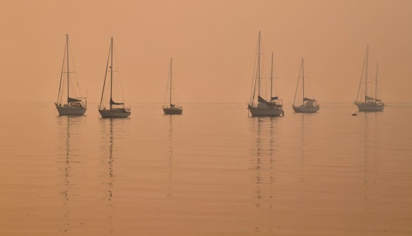 Heavy smoke shrouds yachts moored at Batemans Bay, New South Wales, Australia