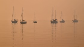 Heavy smoke shrouds yachts moored at Batemans Bay, New South Wales, Australia
