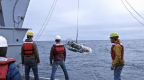 Oceanographers lowering an instrument into Juan de Fuca Canyon to measure fast-moving water close to the seafloor