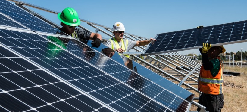 workers installing solar energy farm