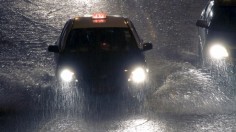 A taxi rides under heavy rain that is causing flooding in Macau, China