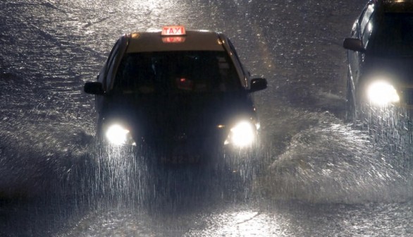 A taxi rides under heavy rain that is causing flooding in Macau, China