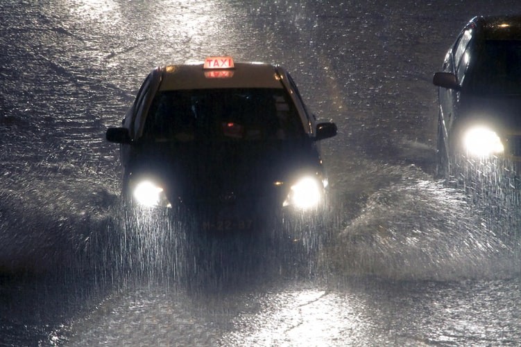 A taxi rides under heavy rain that is causing flooding in Macau, China