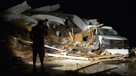 A news video photographer covers the damage seen after a tornado hit the town of Mayflower, Arkansas around 7:30 pm CST, late April 27, 2014