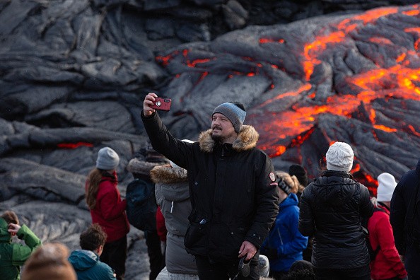 A man takes a selfie in front of the lava field