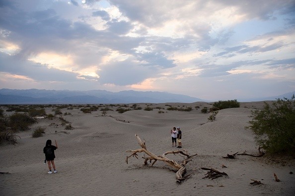 Visitors walk along sand dunes inside Death Valley National Park 