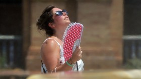 woman cools off faning herself due to the heat