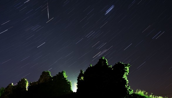 Perseid meteor crossing the night sky and stars trails