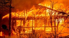 A home is consumed by flames as the Dixie fire rages on in Greenville, California