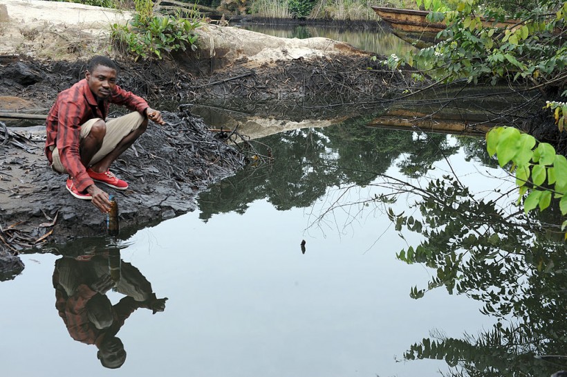 Man scoops spilled crude oil in Niger Delta