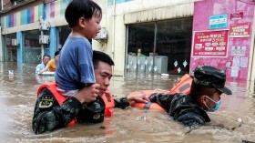 Rescuers evacuating a child from a flooded area after torrential rains in Suizhou