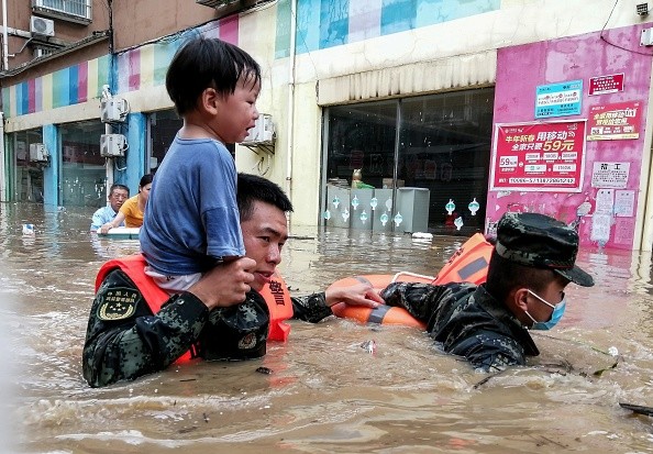 Rescuers evacuating a child from a flooded area after torrential rains in Suizhou