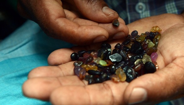  Sri Lankan gem dealer holds a palmful of rough precious and semi precious stones in Ratnapura district