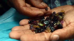  Sri Lankan gem dealer holds a palmful of rough precious and semi precious stones in Ratnapura district