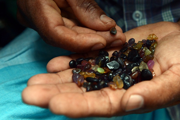  Sri Lankan gem dealer holds a palmful of rough precious and semi precious stones in Ratnapura district