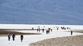 Visitors walk on the salt pan at Badwater Basin in Death Valley National Park