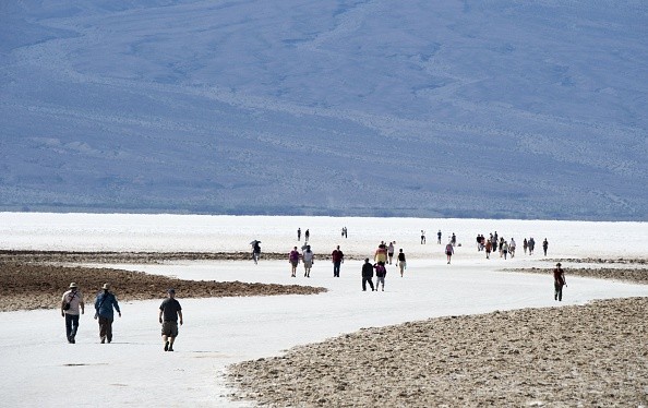 Visitors walk on the salt pan at Badwater Basin in Death Valley National Park