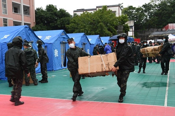 Rescuers transfer supplies near tents set up for people whose homes were damaged by the earthquake