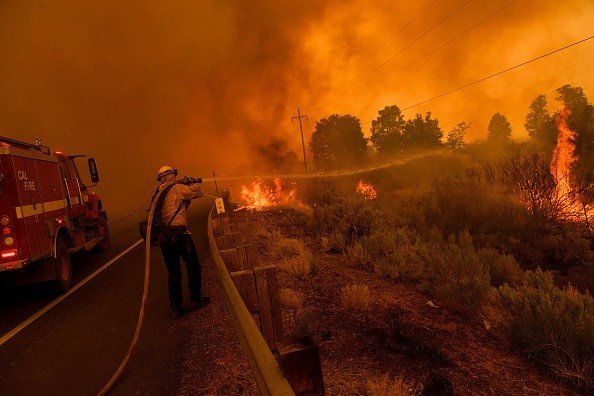  A firefighter trying to contain wildfires potting across Highway 395 during the Dixie Fire 