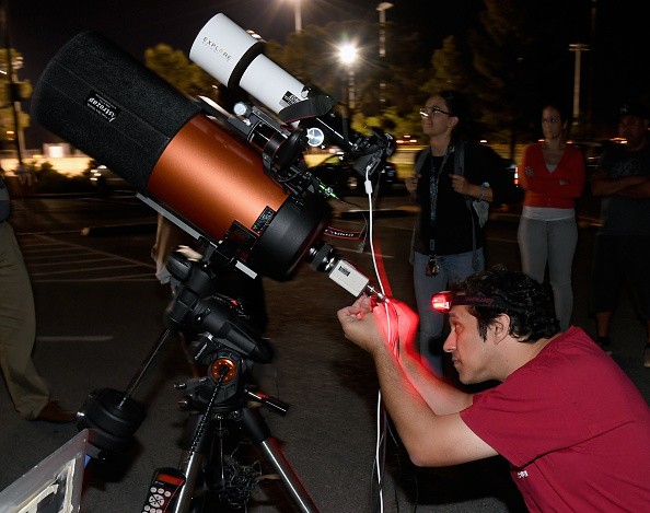 A person setting up a telescope to view asteroid 