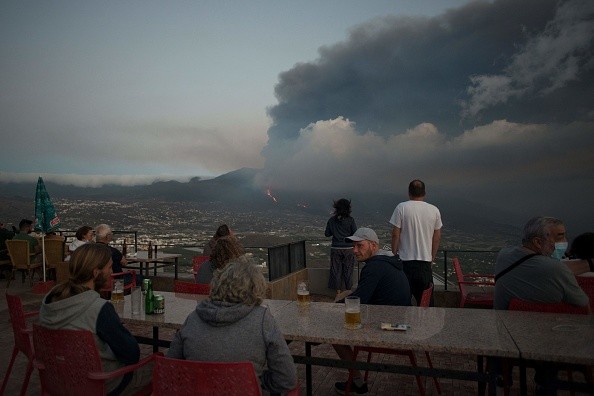 People watching the Cumbre Vieja volcano spews lava, ash and smoke
