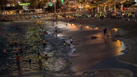 People enjoy an artificial beach after the sun goes down to avoid harmful ultraviolet rays that can cause skin cancer
