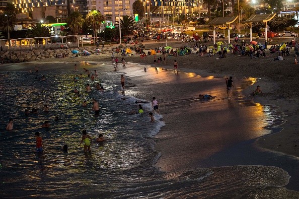 People enjoy an artificial beach after the sun goes down to avoid harmful ultraviolet rays that can cause skin cancer