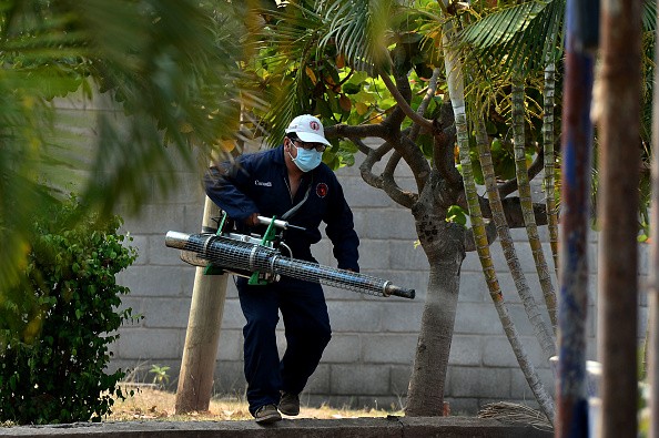 A member of the Health's Secretariat Vector Controls Unit fumigates against mosquitoes